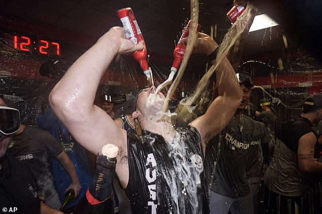 Tommy Kahnle is bathed in alcohol while drinking two beers amid the celebrations.