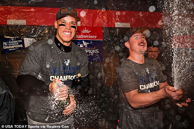 New York captain Aaron Judge (left) sprays champagne after beating the Cleveland Guardians.