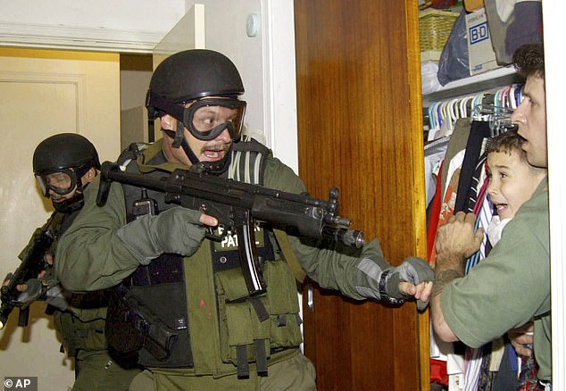 Pictured: Six-year-old Elián González, held in a closet by Donato Dalrymple, right, as government officials search for the boy at his relative's home in Miami on April 22, 2000.