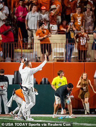 Longhorns coach Steve Sarkisian walks through the student section to encourage students to stop throwing objects on the field after a controversial refereeing call was overturned.