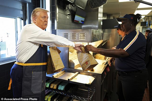 An employee delivers an order to former President Donald Trump, the Republican presidential candidate, during a visit to McDonald's in Feasterville-Trevose, Pennsylvania.