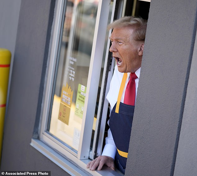 After serving bags of takeout food to people in the self-service lane, Trump leaned out the window, still wearing his apron, to answer questions from the media outside.