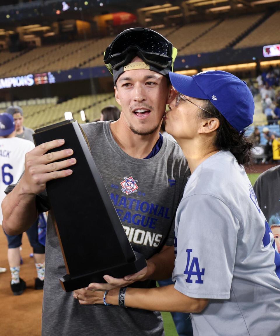 Dodgers shortstop Tommy Edman receives a kiss from his mother on the field at Dodger Stadium.