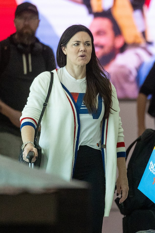 Vanessa wore black tights and white sneakers while walking through the terminal