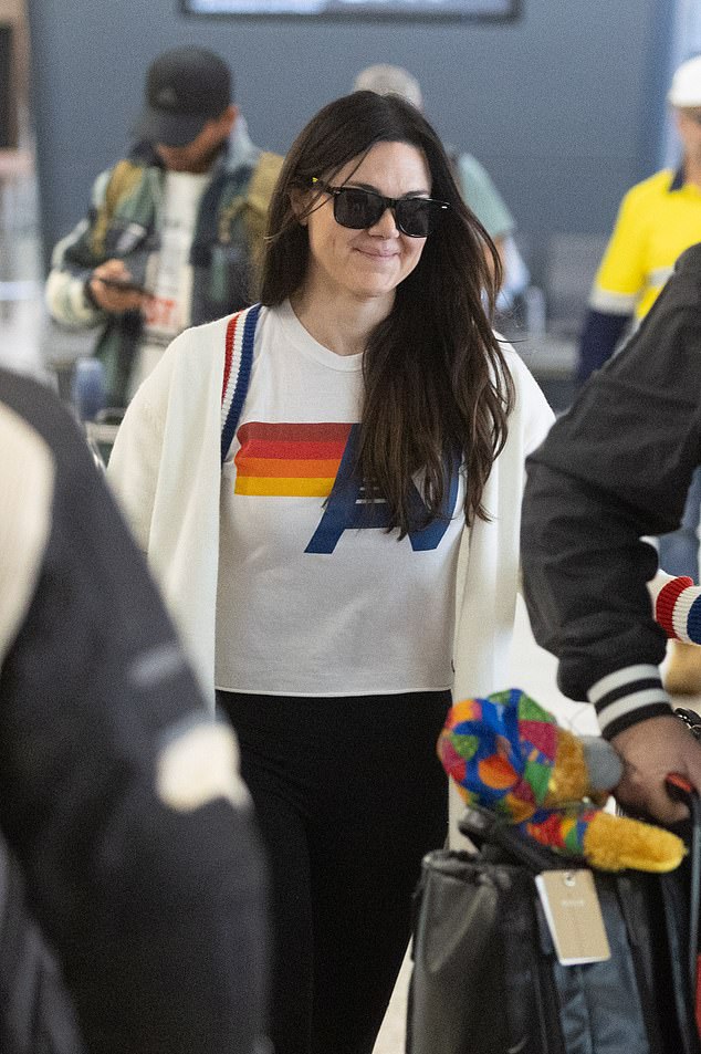 A seemingly shy Vanessa later put on black sunglasses and tried to hide behind a friend as she left Melbourne's Tullamarine Airport.