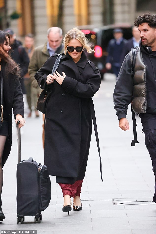 She completed her look with a large black bag and tied her hair in a loose bun and looked a far cry from her raunchy Rivals character.