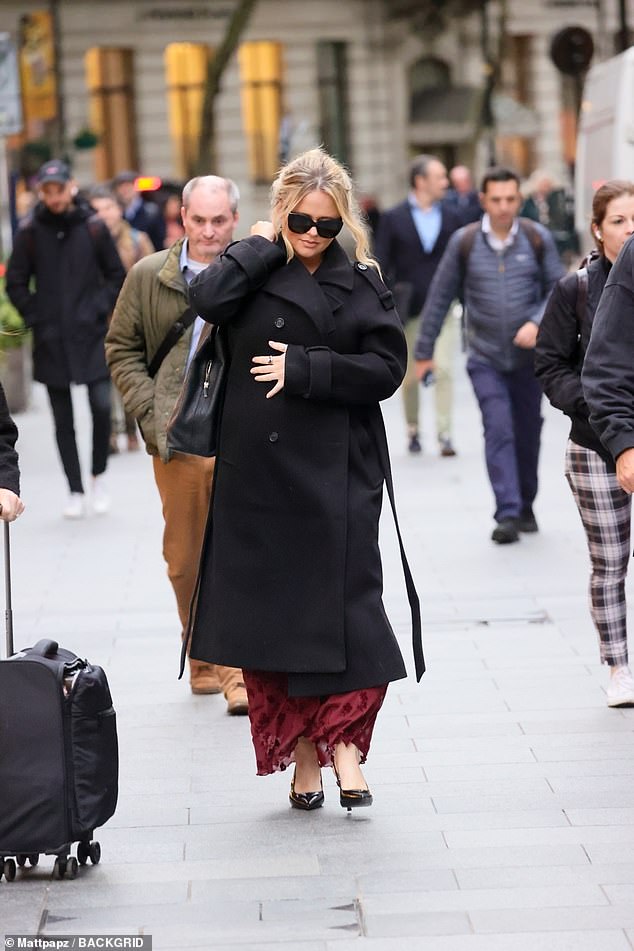 The actress was bundled up for the afternoon chill in a stylish coat worn over a printed red dress and black patent leather heels.