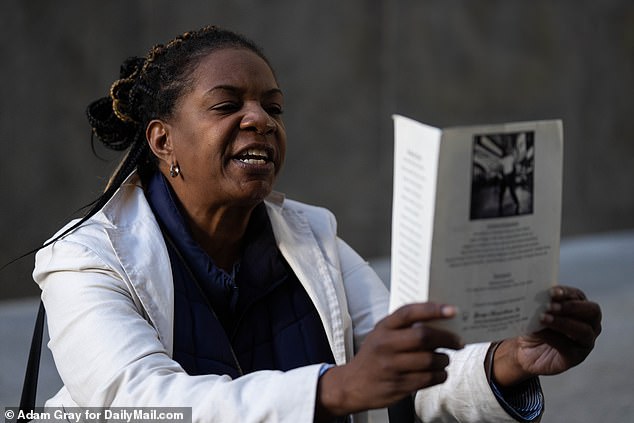 Pictured: A woman holds a funeral order for Jordan Neely before Daniel Penny arrives at Manhattan Criminal Court in New York City on October 21.