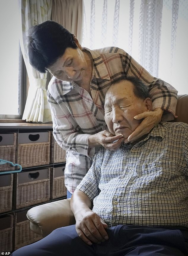 Hideko Hakamada, left, sister of former boxer Iwao Hakamada helps her brother, in 2021