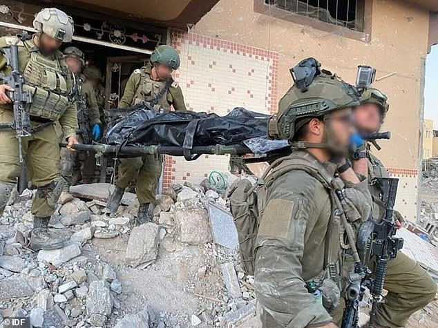 IDF soldiers carry Sinwar's body out of the destroyed building on a stretcher