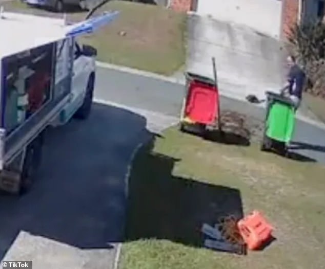 The truck drove away after two failed attempts to empty the container and the man had to shovel the contents off the road.