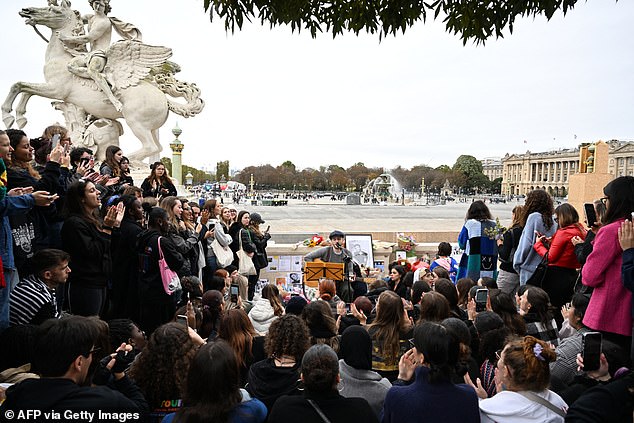 A singer performs as Payne fans gather to pay tribute in the Tuileries Garden in Paris on Sunday.