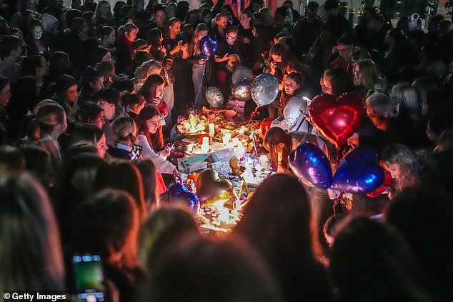 Fans gather during a tribute to Payne at Cathedral Gardens in Manchester on Sunday night.