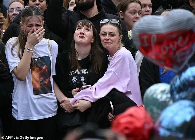 Grieving Londoners gather with balloons next to the Peter Pan statue in Kensington Garden.