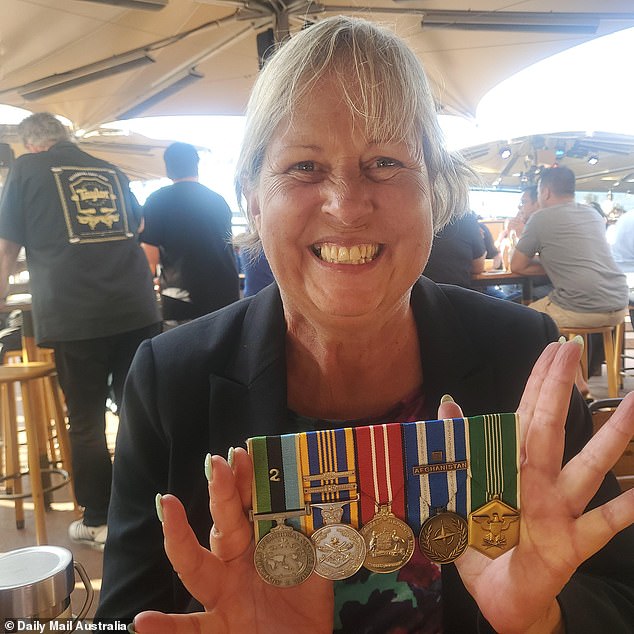 Cath Harvey, a 30-year-old naval veteran, shows off the medals she wore that attracted the royal couple.