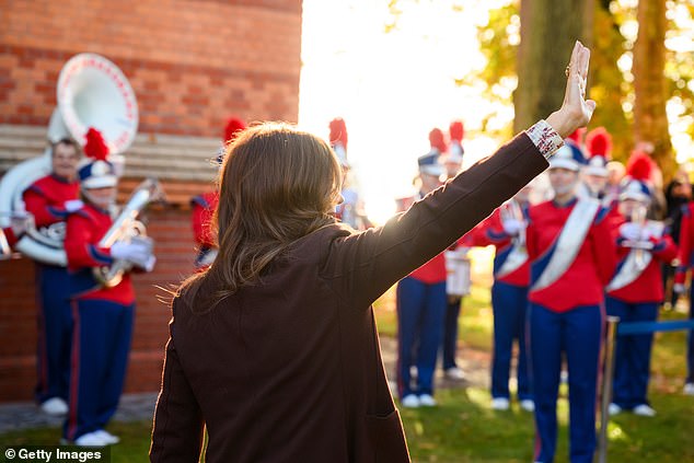 Queen Mary waves to the crowd as a brass band plays to welcome her to Kiel, Germany.