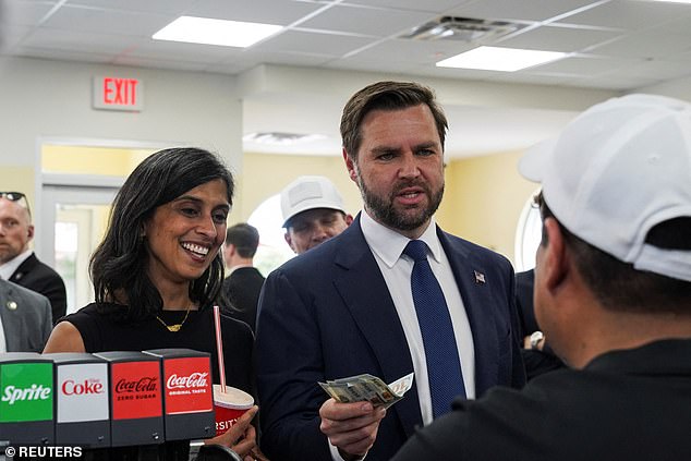 Usha Vance standing next to her husband JD holding money in a varsity on the campaign trail in Rome, Georgia