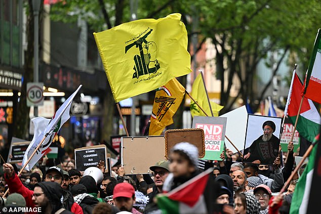 Hezbollah and Hamas are terrorist organizations banned in Australia (pictured, the Hezbollah flag seen during the pro-Palestine rally for Gaza and Lebanon in Melbourne)