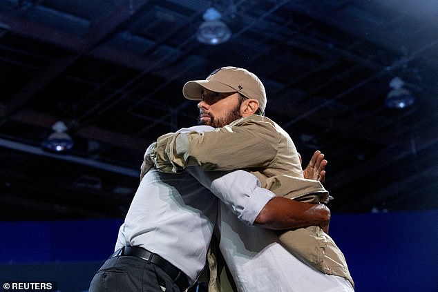 Former President Barack Obama (left) hugs Eminem (right) after the Detroit rapper introduced the former president at a rally supporting Vice President Kamala Harris Tuesday night in the Motor City.