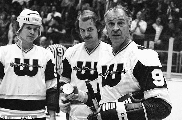 A little fatherly advice as hockey great Gordie Howe accepts a gold record from his sons and teammates Mark and Marty Howe (c) in recognition of his 1,000th goal.