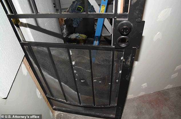 Pictured: The prosecutor says the black metal door Zuberi locked his two victims behind. Here, it is shown from inside the makeshift cell.