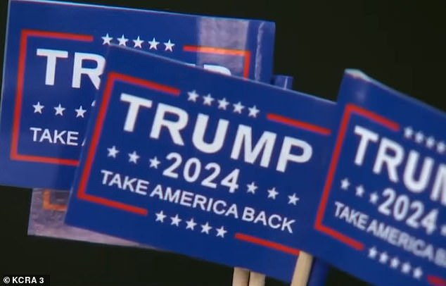 The Trump signs are small, making the driver's actions even more disconcerting.