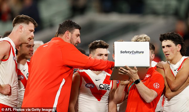 AI will soon be able to provide information accurate enough to override the 'visual test' that coaches use to make tactical changes (pictured, Swans players being coached during a break in play in the 2024 season).