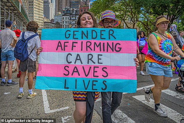 An activist holds a sign painted in the colors of the trans flag in support of gender-affirming care during the Queer Liberation March in New York City last year.