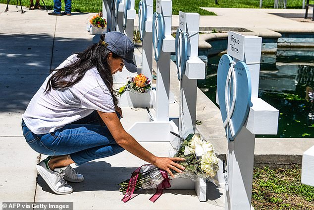 Meghan lays flowers at a makeshift memorial in Uvalde, Texas, two days after a gunman killed 19 students and two teachers and wounded 17 others in May 2022.