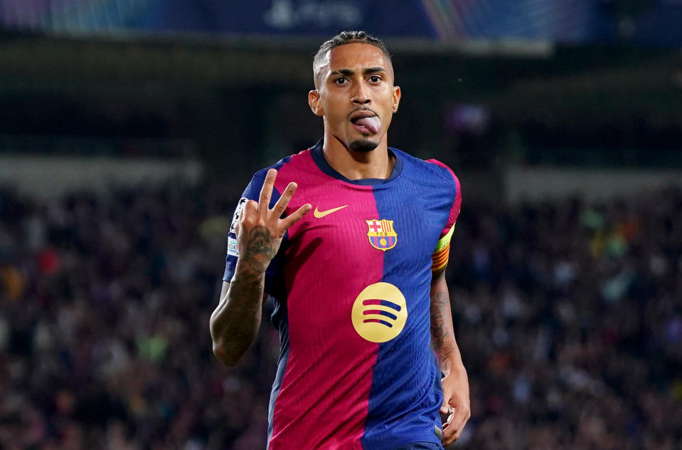 Raphinha raises three fingers after scoring his third goal. (Pedro Salado/Getty Images)