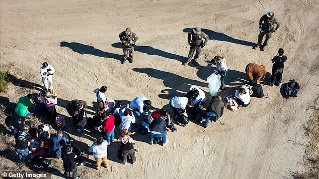 US Border Patrol agents round up a group of Colombian asylum seekers after crossing from Mexico