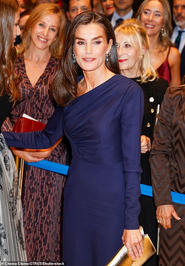 Letizia lit up the room with her broad smile while her silver and sapphire earrings brightened her complexion.