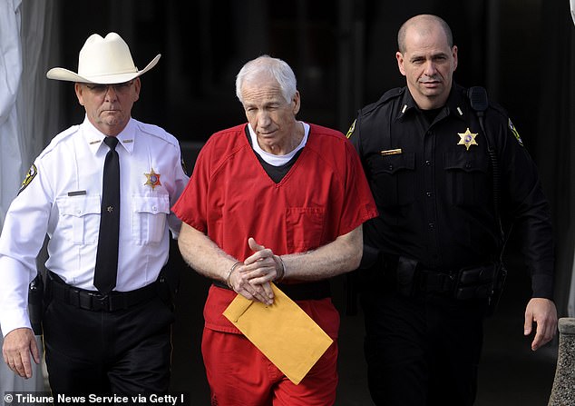 Jerry Sandusky, center, is escorted from his sentencing at the Center County Courthouse in Bellefonte on Tuesday, Oct. 9, 2012.