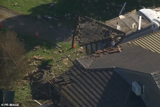 The truck demolished the front of the house, leaving part of the wooden structure hanging in the back of the vehicle.