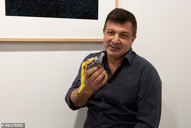 David Datuna, who describes himself as a Georgia-born American artist living in New York, approaches the banana at Galerie Perrotin in Miami and tears it off the wall with the tape attached.