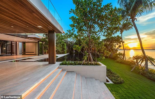 Stairs leading to the garden with palm trees and sea views during sunset.