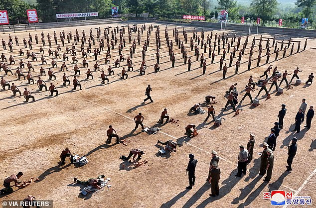 North Korean soldiers are seen breaking concrete blocks in a demonstration before Kim and senior officials.