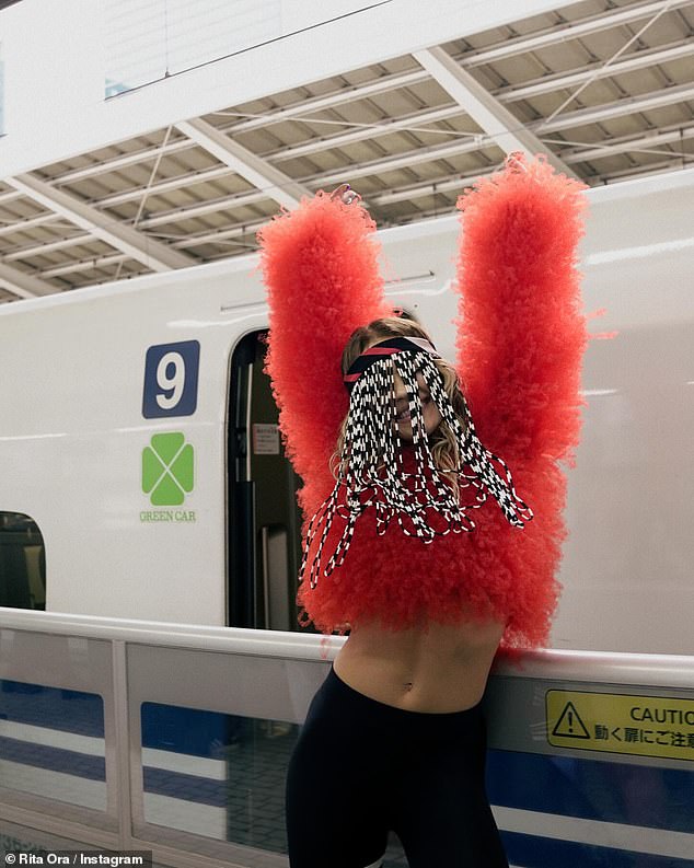 Rita boarded public transportation in Osaka wearing a fluffy red crop top and black leggings.