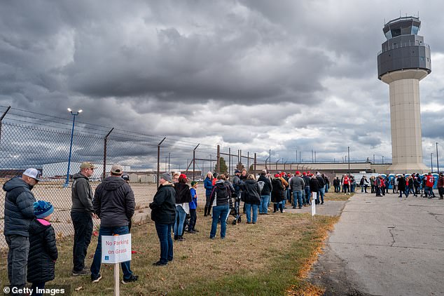 MAGA fans lined up to see Trump, at an event guarded by law enforcement officers with long guns