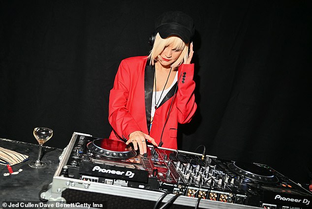 Laura Whitmore was also seen spinning the decks for guests and stood out in a bright red jacket and thigh-high PVC boots.