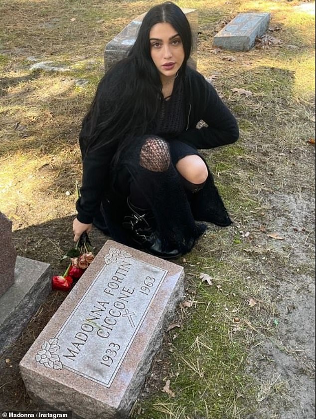 Lourdes, 28, knelt next to her grandmother's tombstone and posed for a photo.