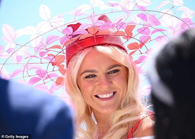 She made sure to turn heads when she paired her elegant ensemble with a unique headpiece, comprised of a bright red hat and rings adorned with colorful leaves.