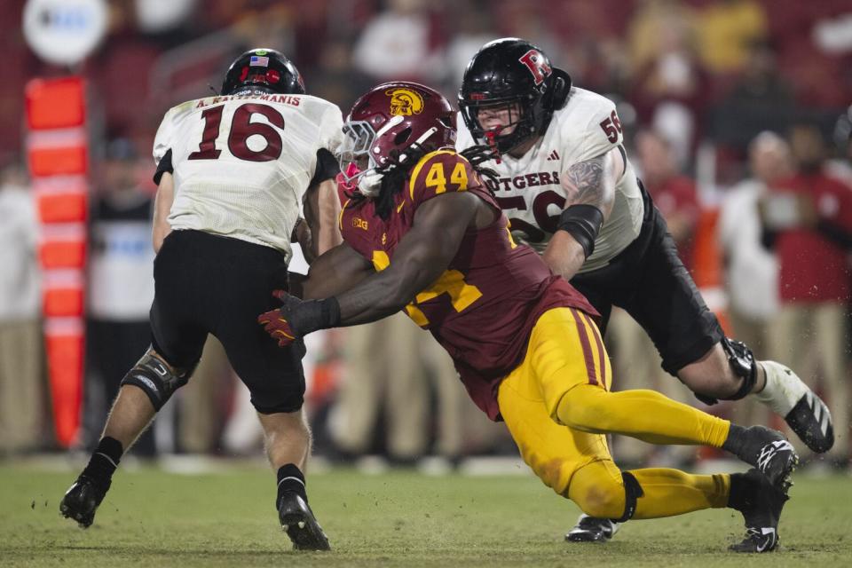 USC defensive end Sam Greene sacks Rutgers quarterback Athan Kaliakmanis on Friday at the Coliseum.