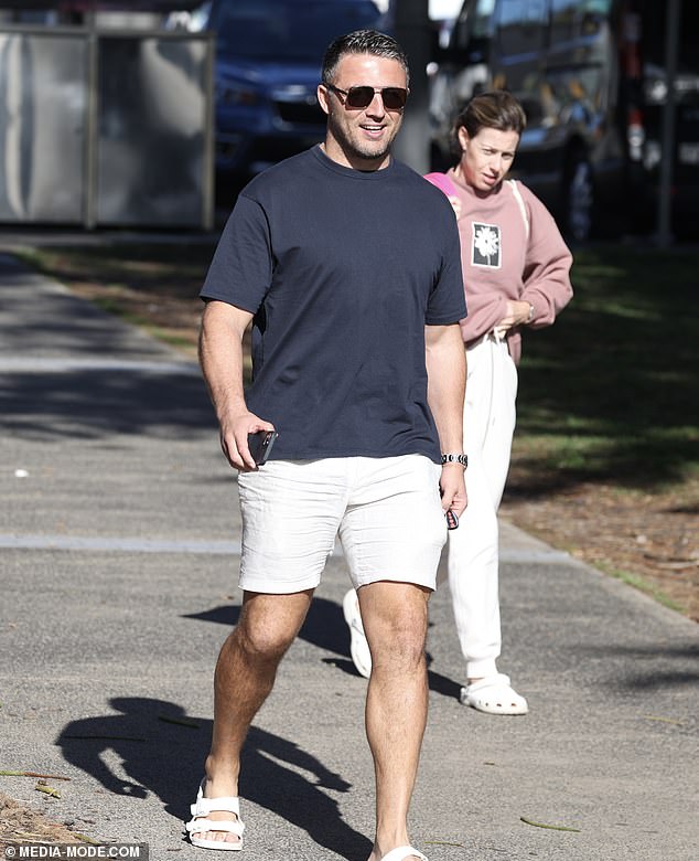 Sam looked comfortable in a pair of beige shorts teamed with a black t-shirt, while accessorizing with sunglasses and off-white Birkenstock sandals.