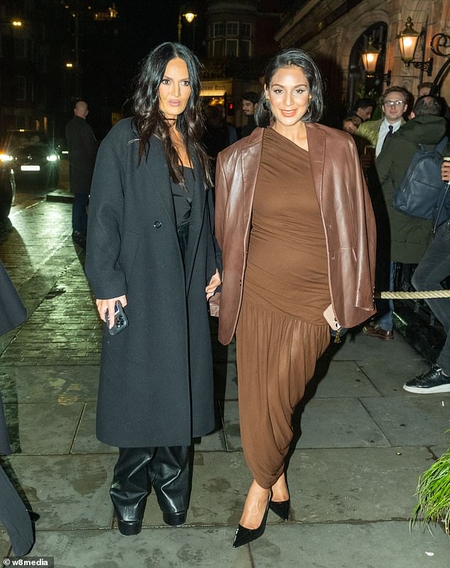 She finished her look with a pair of black platform heels as she posed alongside her friend.