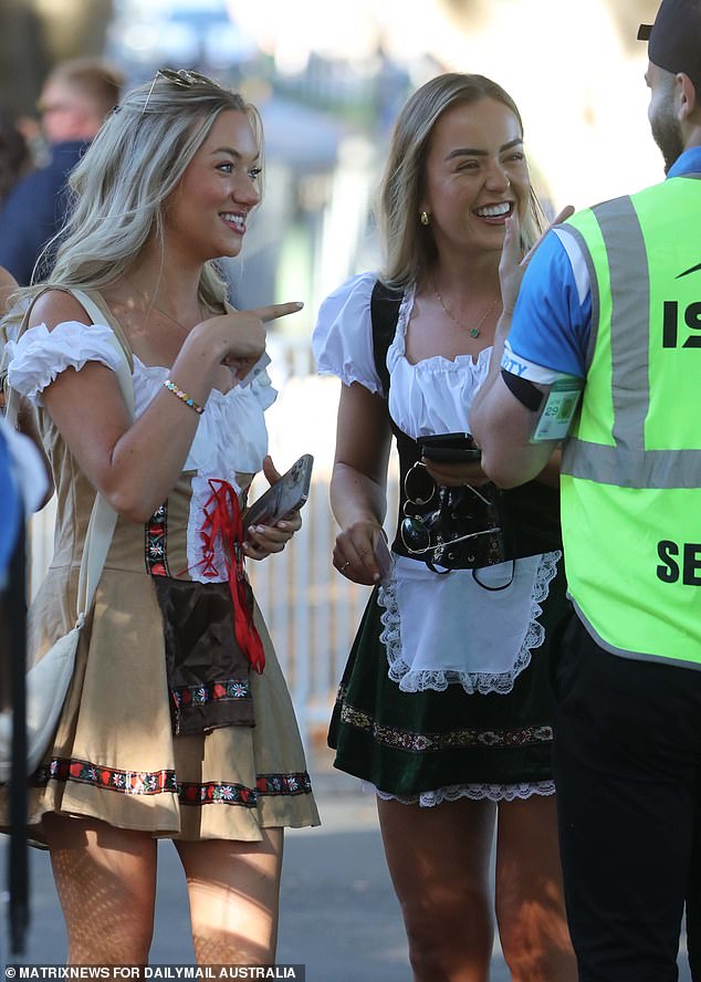 Two revelers share a joke with a security guard