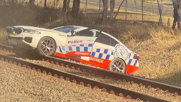 A New South Wales Police spokeswoman said officers are investigating how the incident occurred (pictured, Highway Patrol car stranded on railway tracks near Mount Druitt station).