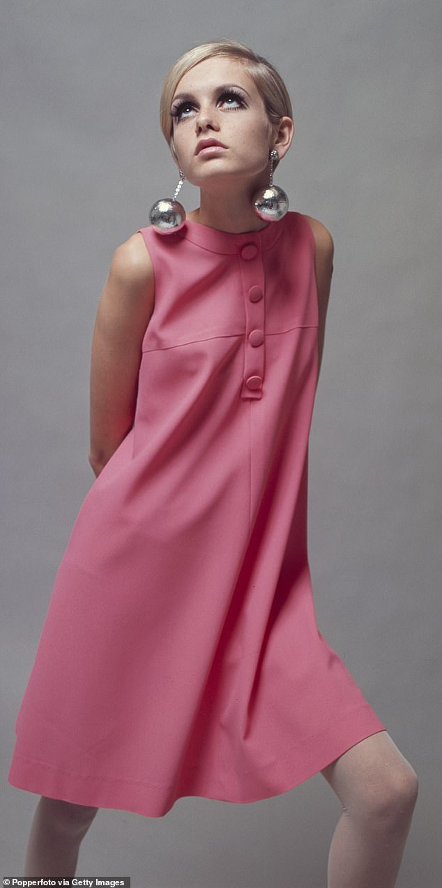 British model Twiggy (Lesley Hornby) wearing a pale pink minidress and large bauble earrings in 1966.