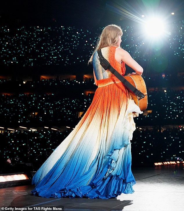 The pop star unveiled the V-neck dress with an orange bodice with a white and blue skirt on Saturday.