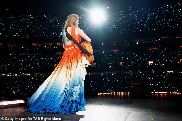 She revealed the asymmetrical V-neck dress with an orange bodice and white and blue skirt while serenading her 83,000 screaming fans at the Caesars Superdome.